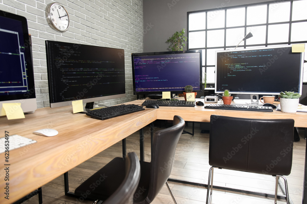 Programmer's workplaces with computer monitors in office Programmer's workplaces with computer monitors in office