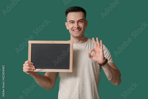 Male teacher with chalkboard showing OK on green background