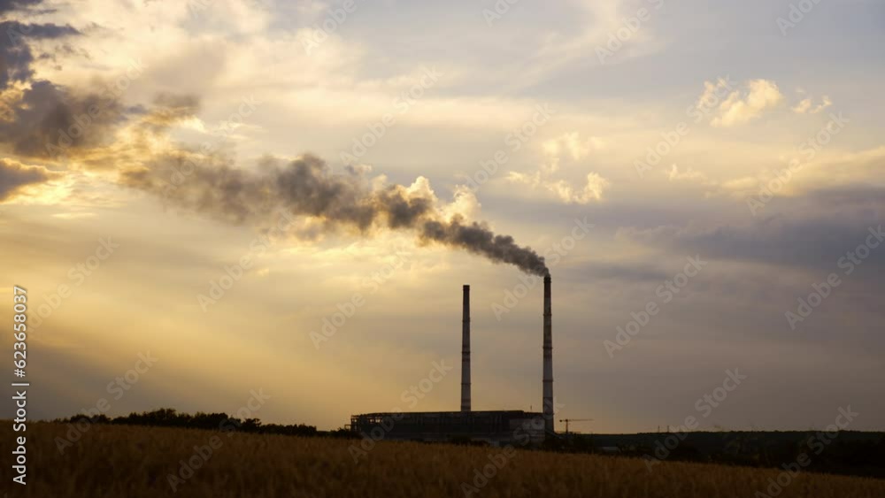 Two plant pipes hovering above the industrial zone. One of the pipes produces heavy smoke. Two plant pipes hovering above the industrial zone. One of the pipes produces heavy smoke.