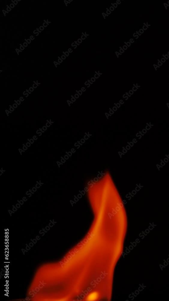 Slow motion flame moving smoothly on a dark background. Close shot, vertical shot. Slow motion flame moving smoothly on a dark background. Close shot, vertical shot.