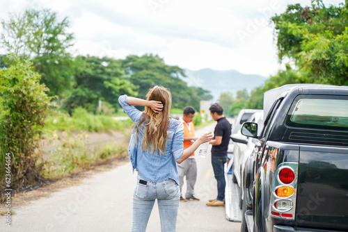 Fotografija Back view of woman waiting her husband with car slide after car accidents on road side