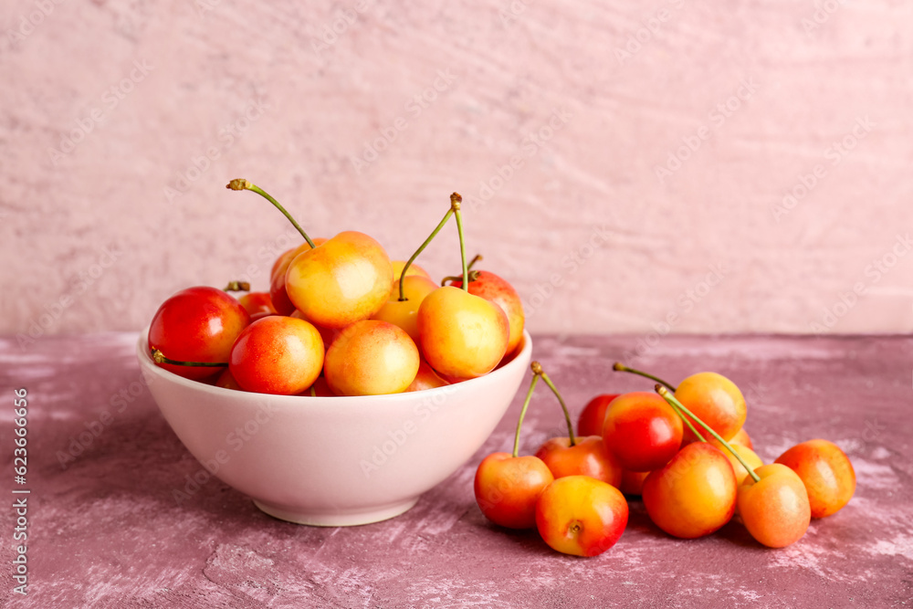 Bowl with sweet yellow cherries on purple background Bowl with sweet yellow cherries on purple background
