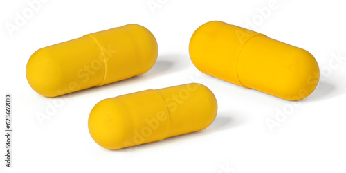 Three yellow capsules with medicament close-up. Full depth of field. With clipping path