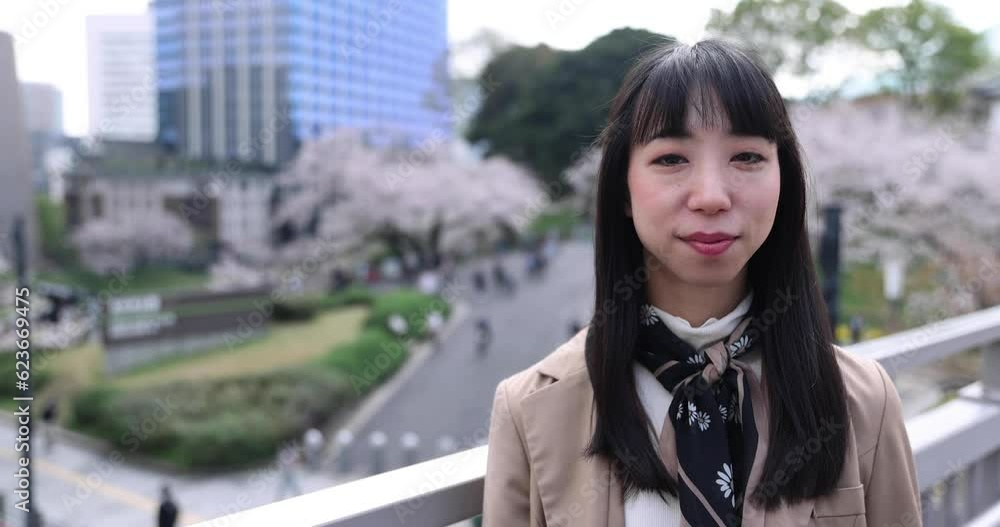 A portrait of Japanese woman behind cherry blossom in Tokyo copyspace A portrait of Japanese woman behind cherry blossom in Tokyo copyspace