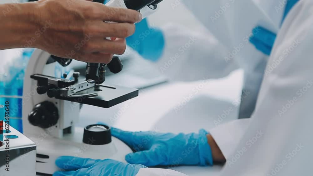 Team of Medical Research Scientists Collectively Working on a New Generation Experimental Drug Treatment. Laboratory Looks Busy, Bright and Modern. Team of Medical Research Scientists Collectively Working on a New Generation Experimental Drug Treatment. Laboratory Looks Busy, Bright and Modern.