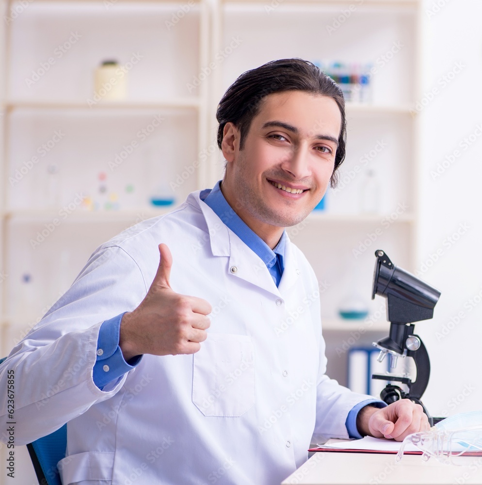 Young male chemist experimenting in lab Young male chemist experimenting in lab