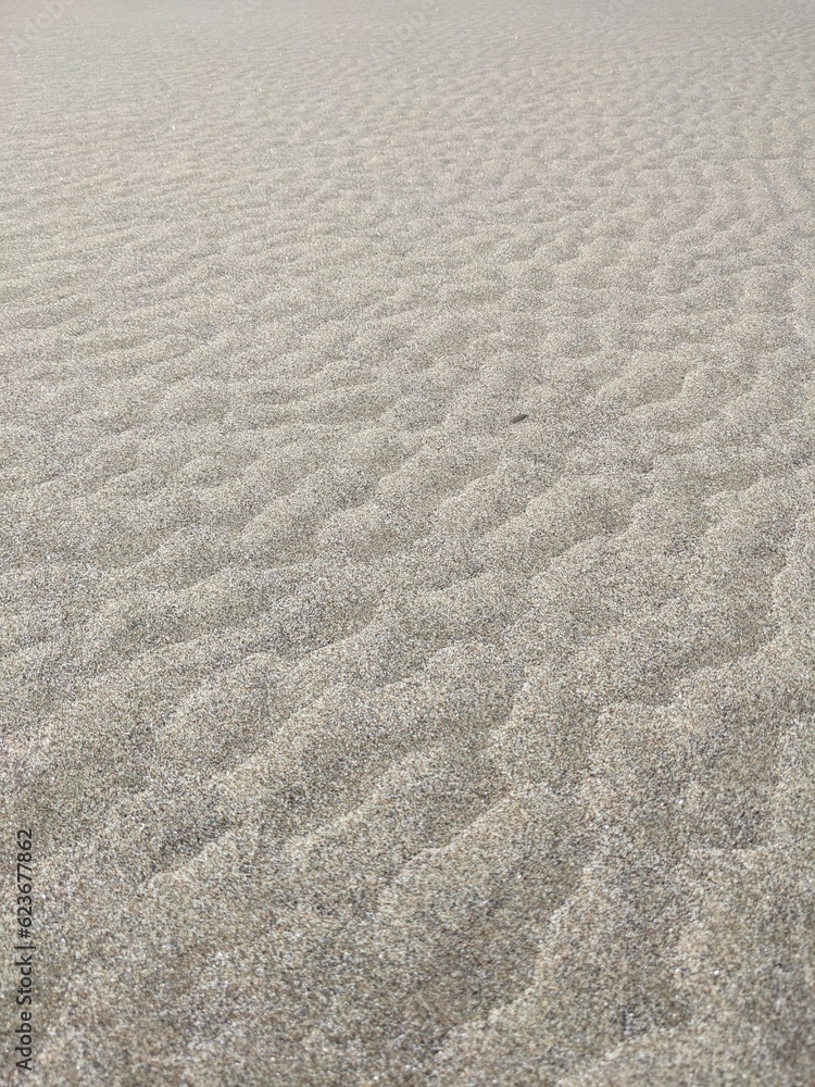 Angled view of beach sand with periodic pattern from the ebb and flow of water. Angled view of beach sand with periodic pattern from the ebb and flow of water.