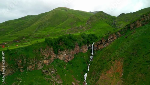 Arsha waterfall in green mountain kazbegi, view from flying drone - stock video georgia photo