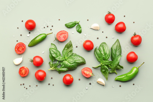 Fresh basil, cherry tomatoes and peppercorn on green background