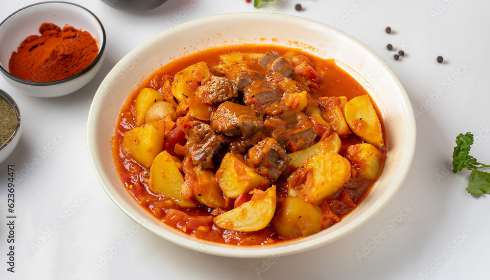Potatoes stewed with meat, in tomato sauce, with spices and herbs, no people, on a white table, Potatoes stewed with meat, in tomato sauce, with spices and herbs, no people, on a white table,