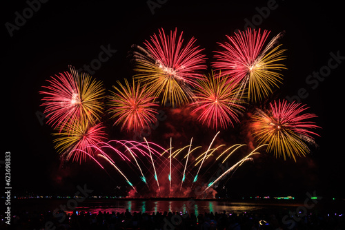 PATTAYA, CHONBURI, THAILAND Beautiful colorful fireworks night scene at Pattaya International Fireworks Festival and silhouette Group of tourist take pictures of firework show on the beach,. photo