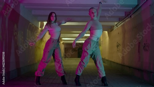 Urban dance couple of dancers in neon light. Rhythmic dances to the beat of the music in the city in the underground passage. High quality 4k footage