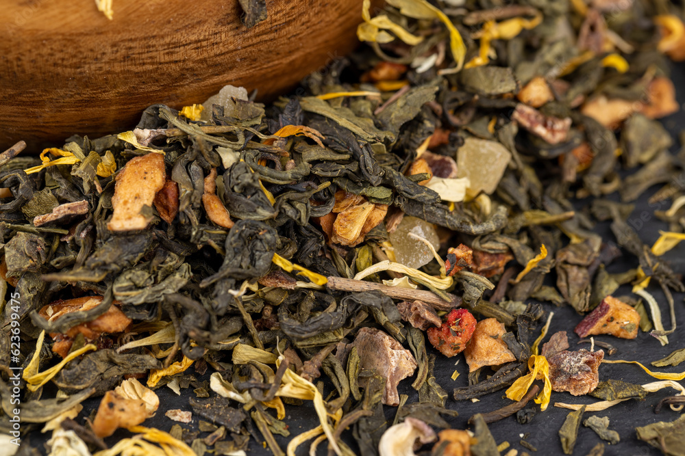 A large amount of dry green tea with pieces of fruit A large amount of dry green tea with pieces of fruit