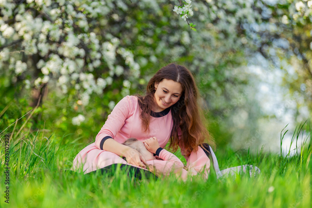 mother and daughter sit outdoors in a blooming garden mother and daughter sit outdoors in a blooming garden