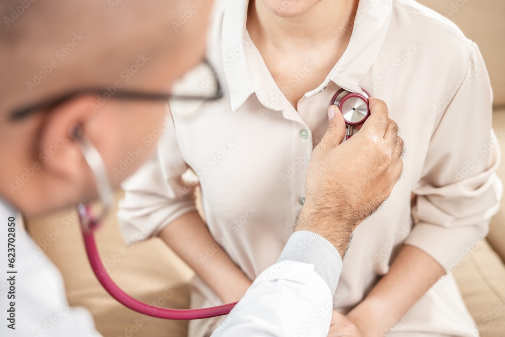 Medical and health care concept, Close up of male doctor using stethoscope putting beat heart diagnose with patient in examination room at a hospital. Medical and health care concept, Close up of male doctor using stethoscope putting beat heart diagnose with patient in examination room at a hospital.