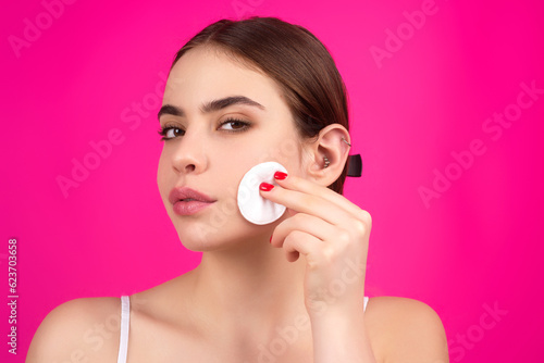 Woman with cotton pad. Toner for cleaning make up. Clean healthy skin, studio background. Beauty woman holding cotton pad, applying cleansing lotion facial wipe on face, removing makeup.