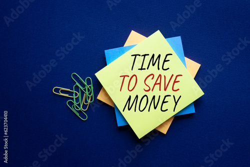 Time to save money symbol. Yellow steaky note with words Time to save money. Beautiful deep blue background. Business and Time to save money concept. Copy space. photo