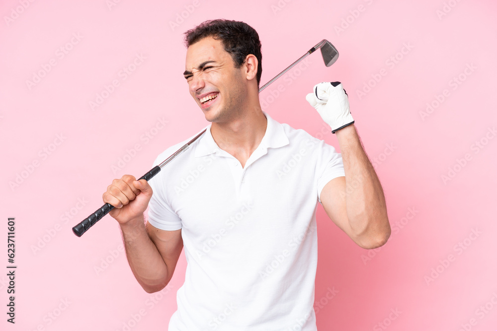 Young golfer player man isolated on pink background celebrating a victory Young golfer player man isolated on pink background celebrating a victory