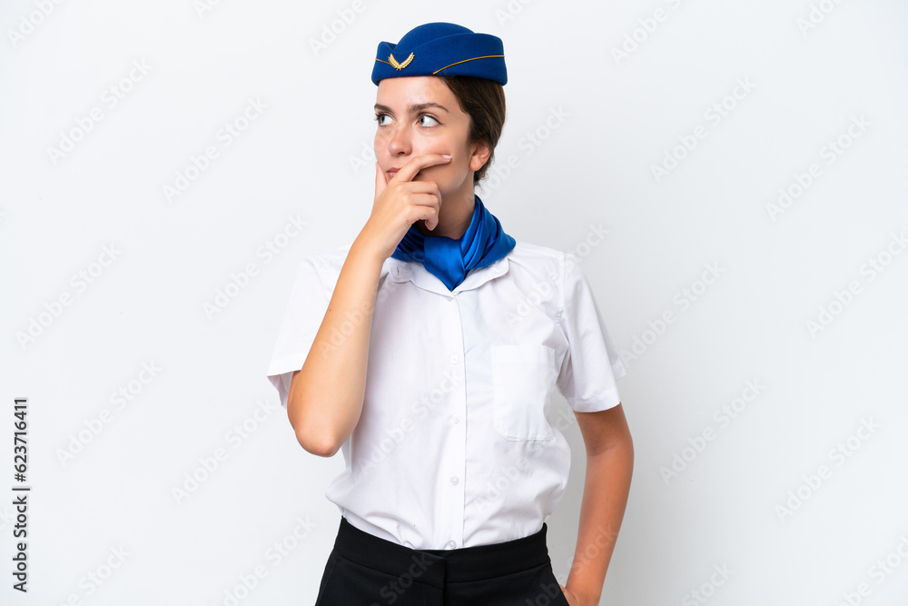 Airplane stewardess caucasian woman isolated on white background having doubts and with confuse face expression Airplane stewardess caucasian woman isolated on white background having doubts and with confuse face expression