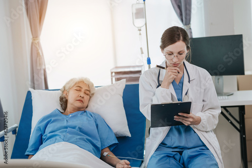 professional female doctor treating elderly patients on hospital beds