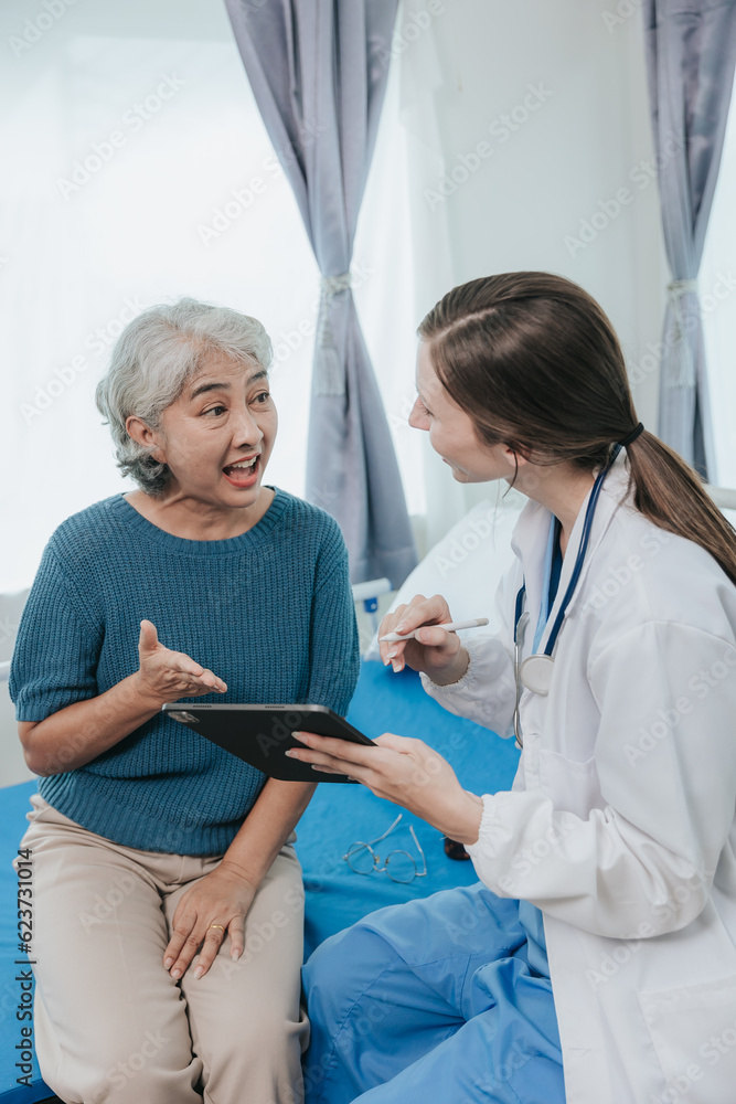 Obraz premium Beautiful modern female doctor talking to an elderly woman patient with a smiling face at the hospital.