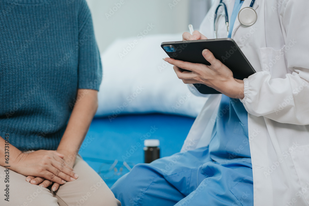 Beautiful modern female doctor talking to an elderly woman patient with a smiling face at the hospital.