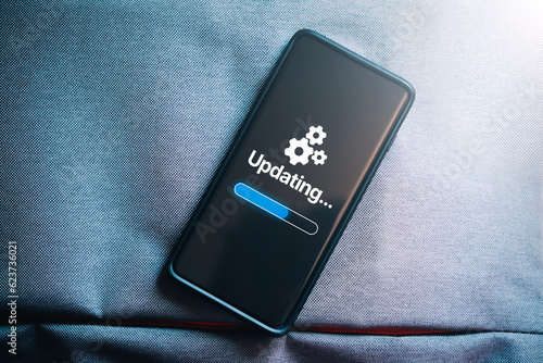 Obraz na płótnie Top view photo of smartphone with updating software on screen. System engineer and programming. Software apps developer.