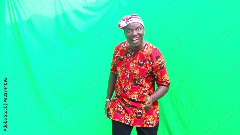 Igbo business man in 3D marketing presentation of imaginary products falling from the sky and happy dancing in front of green screen that can be digitally removed Igbo business man in 3D marketing presentation of imaginary products falling from the sky and happy dancing in front of green screen that can be digitally removed