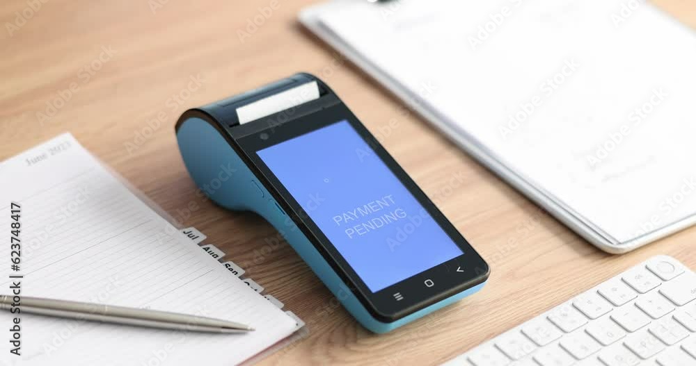 Closeup of hand holding credit card and an approved payment on terminal. Payment for services of goods with bank card and cashback Closeup of hand holding credit card and an approved payment on terminal. Payment for services of goods with bank card and cashback