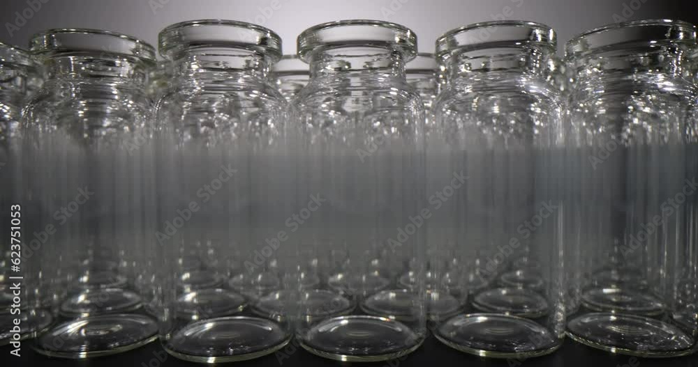 Glass vials for liquid samples of vaccines on dark background. Laboratory equipment for dispensing liquid samples Glass vials for liquid samples of vaccines on dark background. Laboratory equipment for dispensing liquid samples