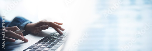 Business woman hands typing on laptop computer keyboard, surfing the internet at the office with copy space for web banner, Woman worker and business concept. photo