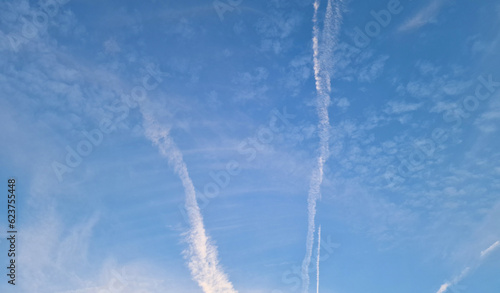 View of light clouds and aircraft trails