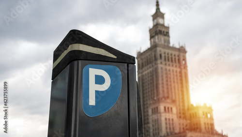 Parking meter, Parkometr or Parkomat in paid parking zone of Warsaw, Poland city centre downtown district. Car park pay and display ticket machine. Palace of Culture and Science in background.