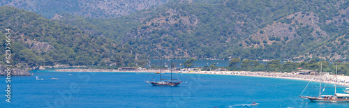 Panoramic view of Kumburnu beach in Oludeniz (Blue Lagoon) district. Mugla, Turkey - July 10, 2023.