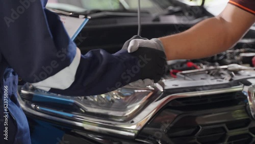 Close up of 2 mechanic hands in gloves making handshake in front of a car