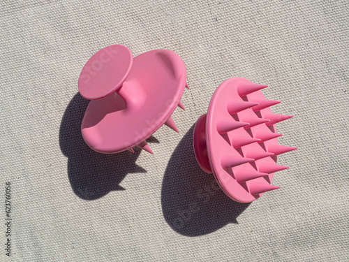 Pink silicone scalp massager mockup. Hair brush with long shadow. Summer flatlay