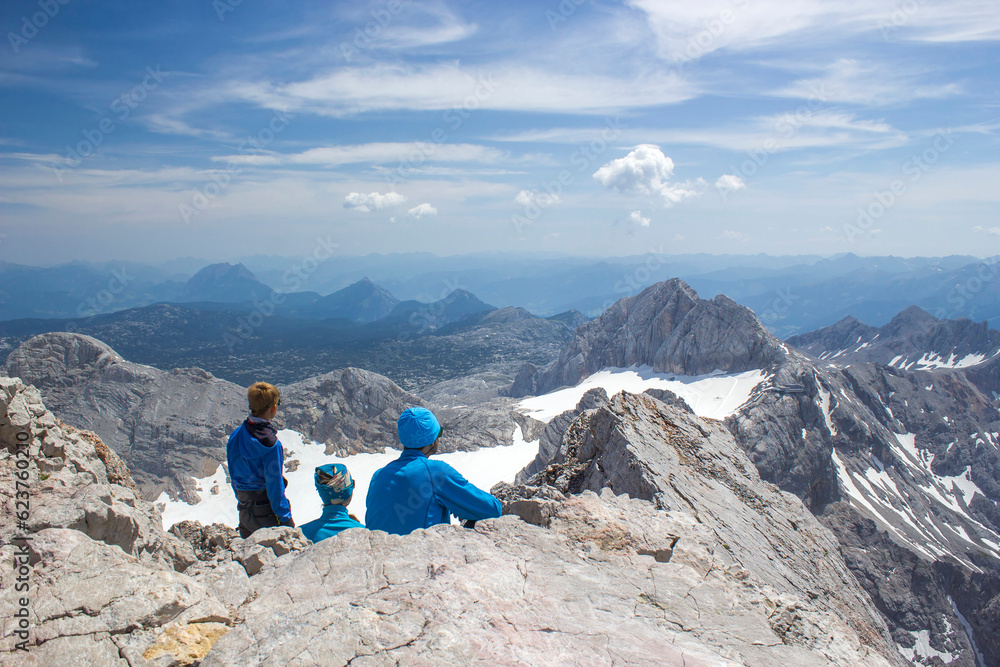 hikers on a top of Dachstein -  Panorama of massive Alpine mountains. LHikers on a top of Dachstein - landscape in the Austrian Alps of the Dachstein region
