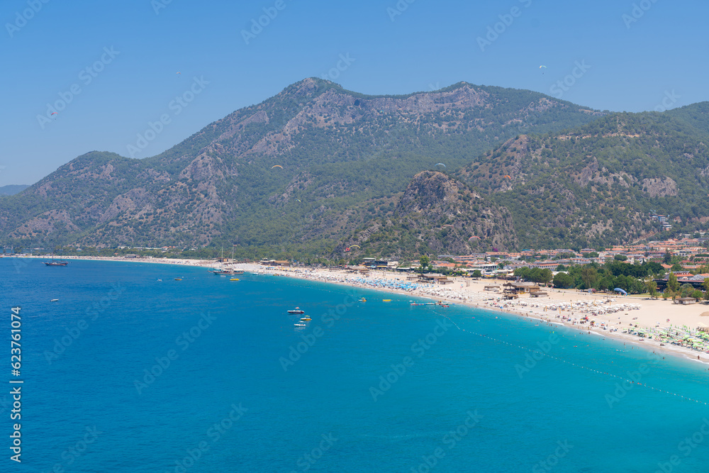 Panoramic view of tourists sunbathing and swimming on the Belcekiz (Belcegiz) Beach in Oludeniz (Blue Lagoon) district.