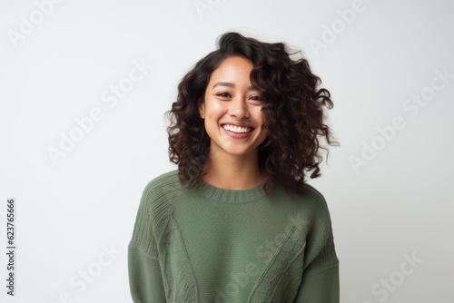 Portrait of a smiling young woman with curly hair over white background