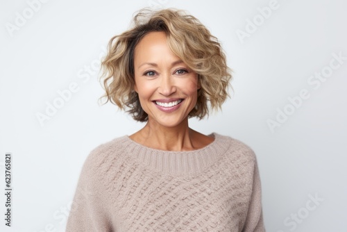 Portrait of a beautiful middle aged woman smiling at camera over white background
