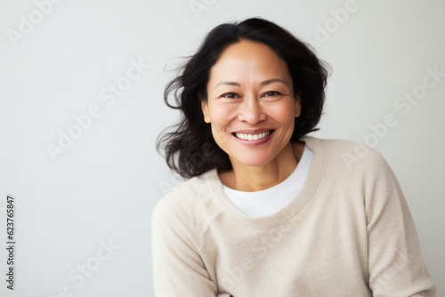 Portrait of smiling asian woman looking at camera over white background
