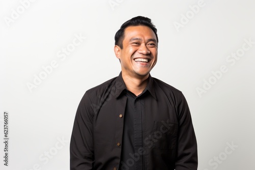 Portrait of happy young asian man laughing and looking at camera