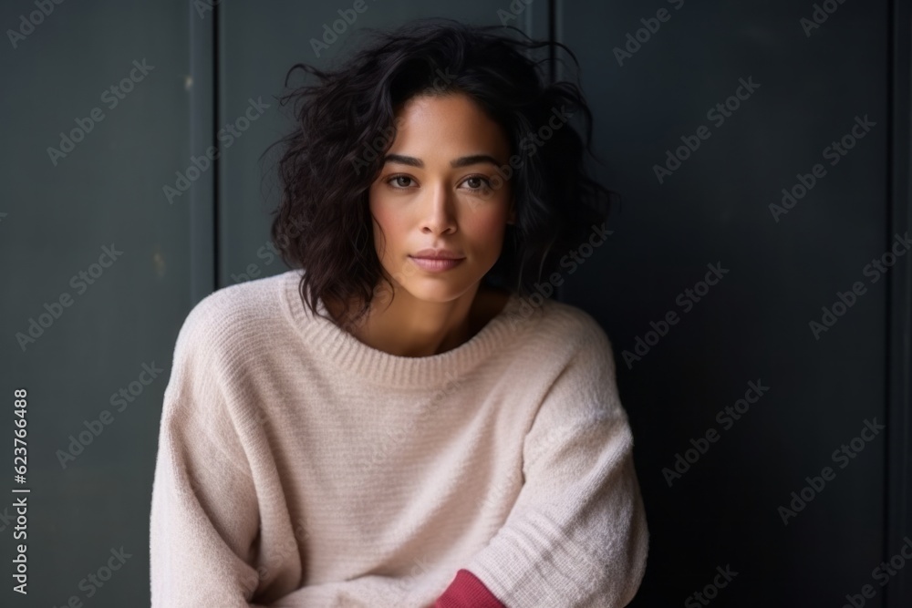 Medium shot portrait photography of a serious Indonesian woman in her 30s wearing a cozy sweater against an abstract background Medium shot portrait photography of a serious Indonesian woman in her 30s wearing a cozy sweater against an abstract background