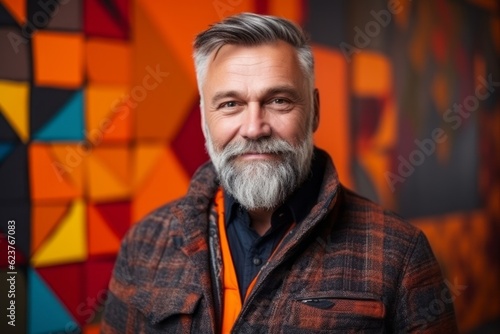 Portrait of a handsome mature man with gray beard and mustache in checkered jacket