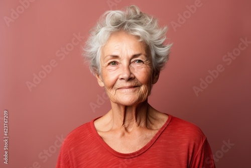 Portrait of a smiling senior woman with grey hair posing at studio