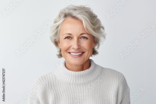 Portrait of beautiful middle-aged woman in white sweater smiling at camera