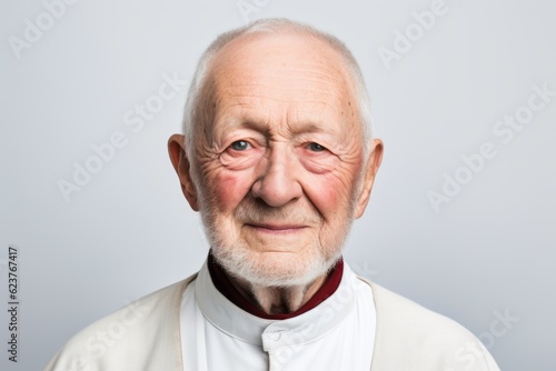 Portrait of an old man in a white T-shirt on a gray background