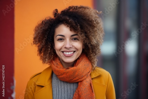 Portrait of smiling young woman with afro hairstyle wearing scarf and coat