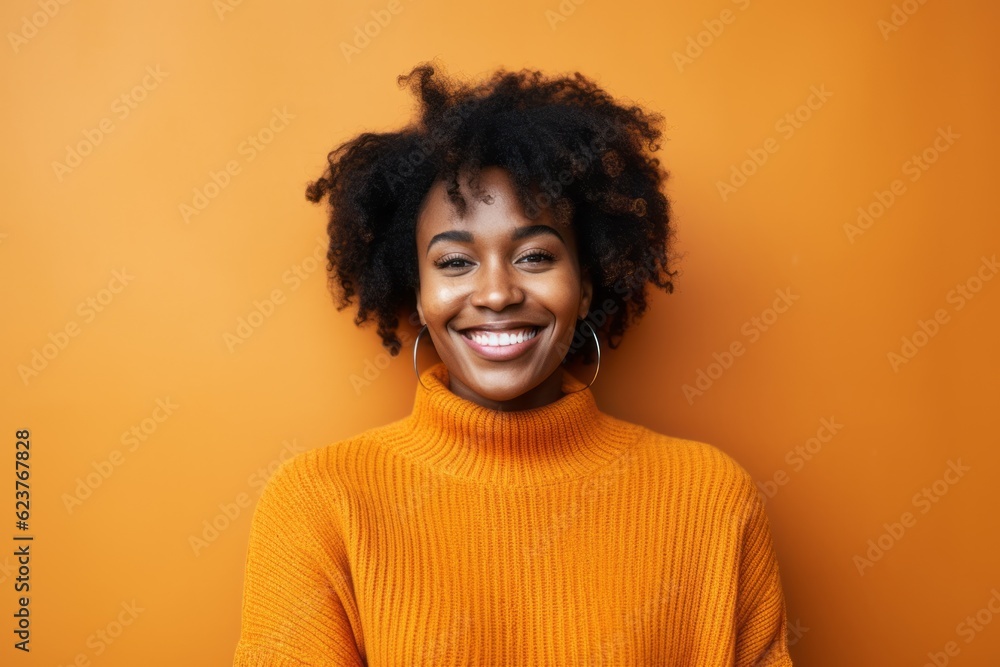 Portrait of a beautiful young african american woman smiling against orange background Portrait of a beautiful young african american woman smiling against orange background