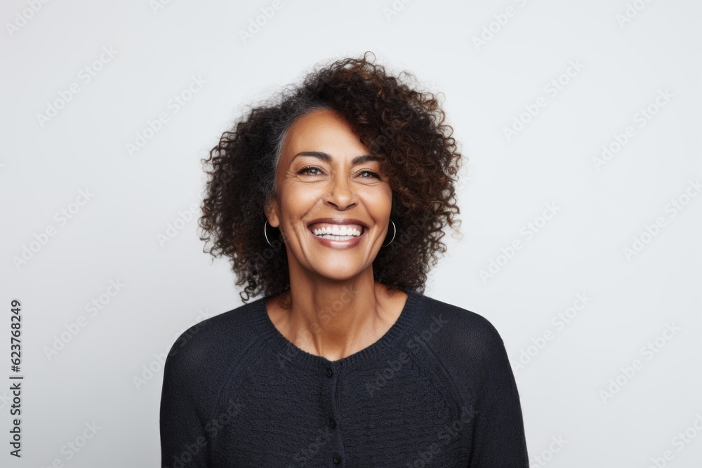 Portrait photography of a happy Brazilian woman in her 50s wearing a chic cardigan against a white background Portrait photography of a happy Brazilian woman in her 50s wearing a chic cardigan against a white background